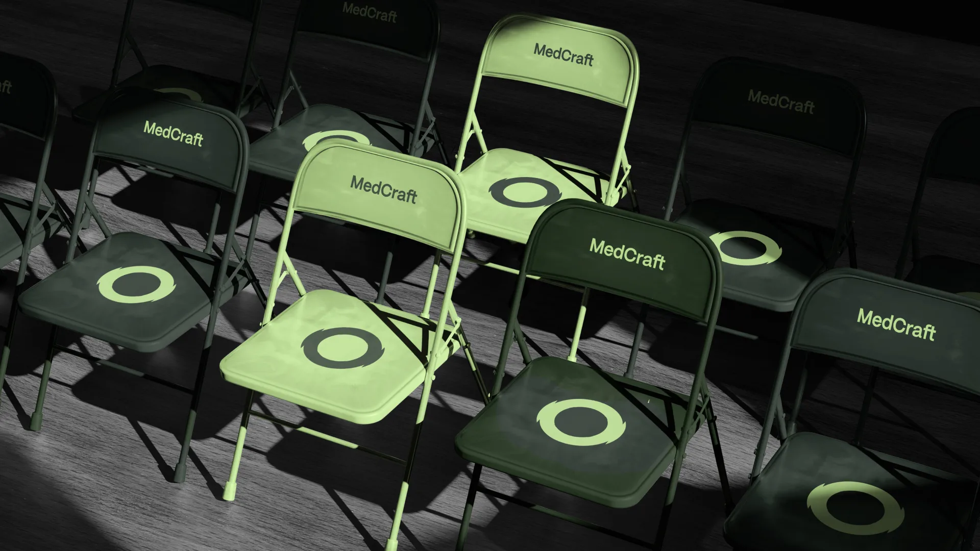 Rows of folding chairs in the two brand greens, each printed with MedCraft and the ring mark